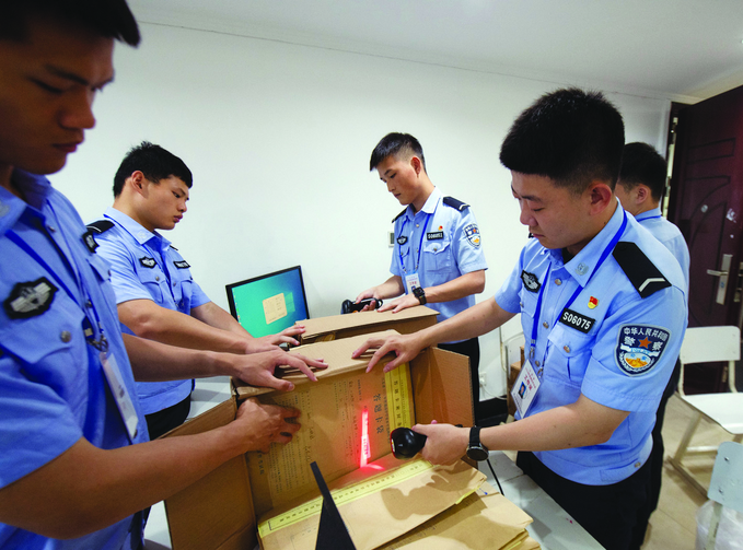 在省教育考試院試卷掃描點(diǎn)，工作人員對(duì)答題卡進(jìn)行拆箱掃描、信息入庫(kù)。楊素平攝