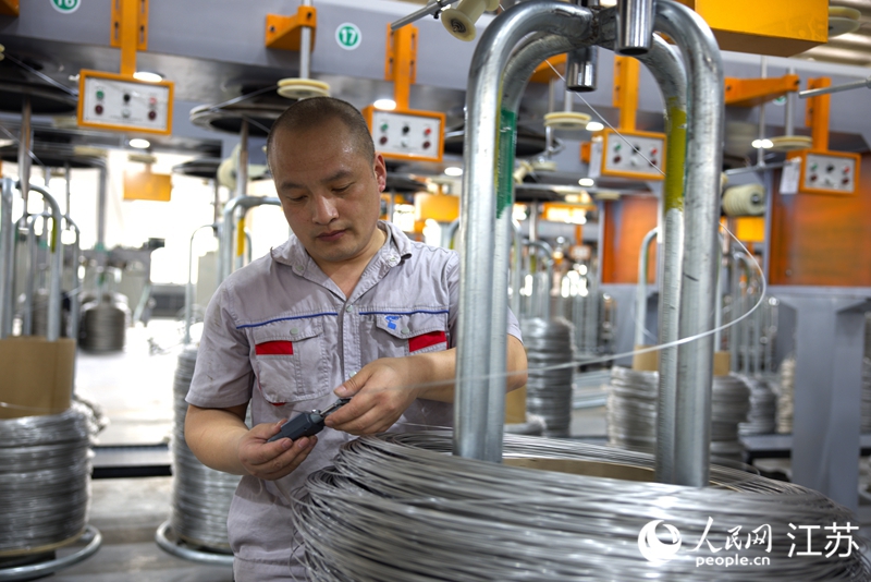 江蘇騰龍精線工人在抽檢不銹鋼絲線徑。人民網(wǎng) 范堯攝