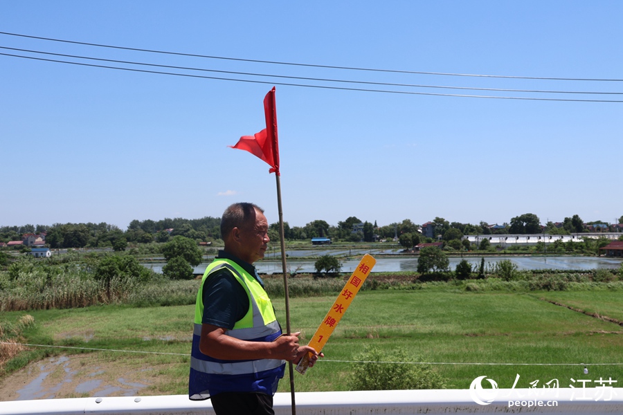 徐小寶手持“水牌”在巡堤。人民網(wǎng) 楊維瓊攝