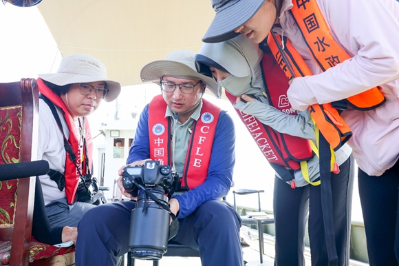 調(diào)查隊(duì)成員查看拍攝的江豚畫面。盛義攝