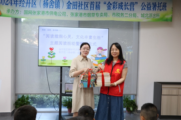 志愿者代表向金田社區(qū)捐贈(zèng)書籍。張家港煙草供圖
