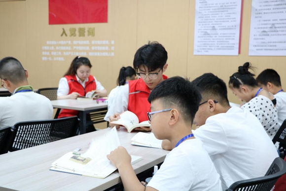 志愿者與學(xué)生共同閱讀。張家港煙草供圖