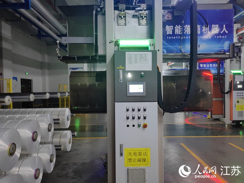 江蘇桐昆恒陽化纖有限公司生產車間里的智能落筒機器人。人民網 黃啟源攝