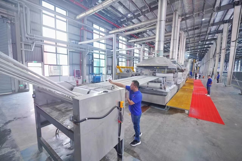 江蘇新瑞邦纖維科技有限公司生產車間內，工人在生產線上忙碌。焦尉攝