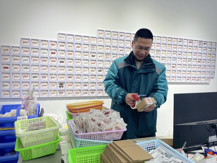 郵政工作人員協(xié)助客戶打包穿戴甲郵件。江蘇郵政供圖