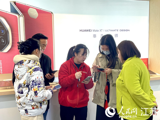 導(dǎo)購員協(xié)助消費(fèi)者領(lǐng)取補(bǔ)貼。人民網(wǎng) 江楠攝