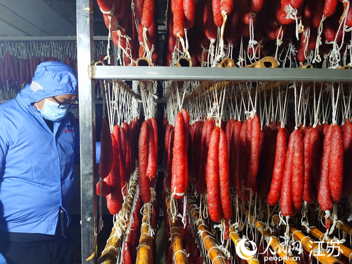 李曉星在烘房檢查最后一批香腸的干濕狀況。人民網(wǎng)記者 王繼亮攝