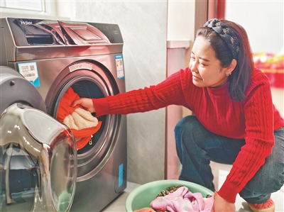 趙海的妻子安娟娟在使用智能洗衣機(jī)。段海攝