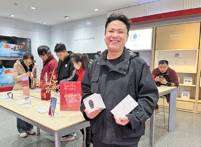 馬瑞晨展示購(gòu)買(mǎi)的手機(jī)和智能手表。本報(bào)記者?姚雪青攝