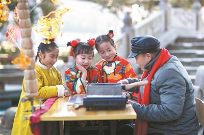 在興化市八字橋廣場(chǎng)，小朋友近距離觀看糖畫(huà)非遺代表性傳承人現(xiàn)場(chǎng)制作糖畫(huà)，感受糖畫(huà)的獨(dú)特魅力。 施 覺(jué)攝（影像中國(guó)）