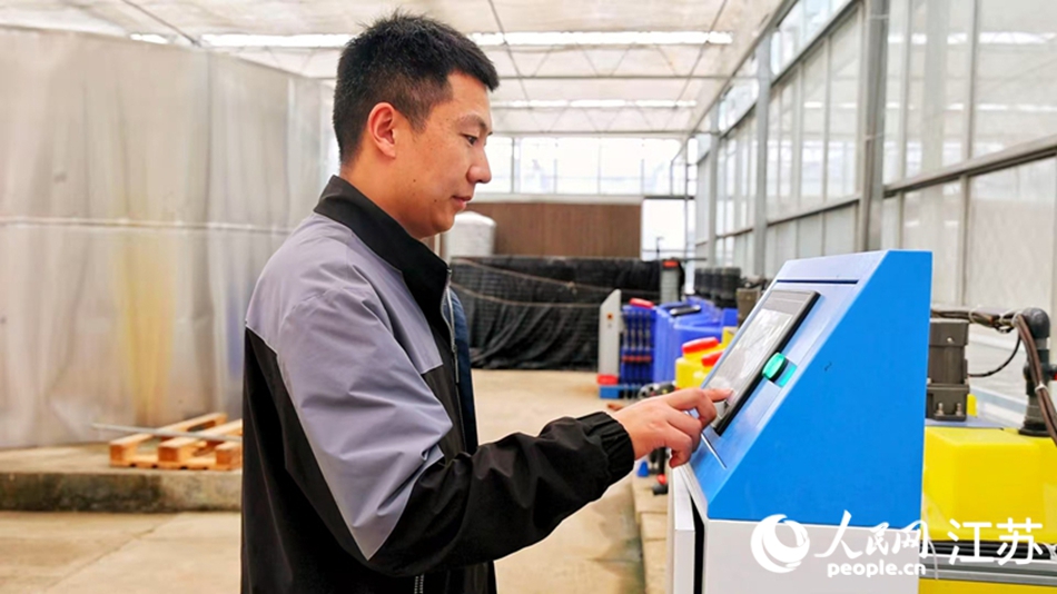 農(nóng)技人員操作智能系統(tǒng)，為番茄植株設(shè)定施肥量和滴灌頻率。人民網(wǎng) 張瀚天攝