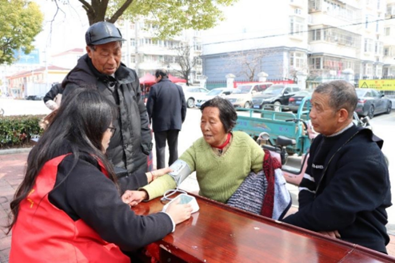 志愿者幫助群眾量血壓。泰州煙草供圖