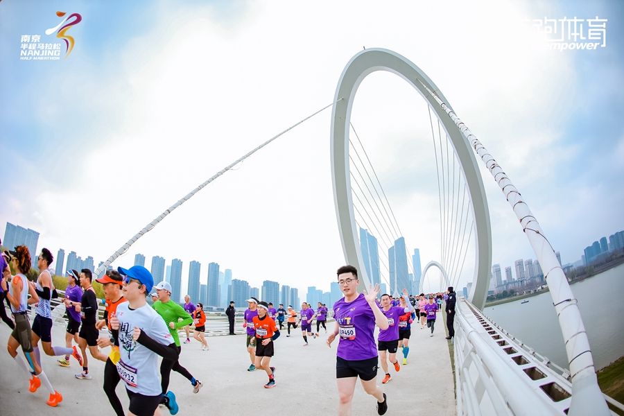 跑者經(jīng)過(guò)南京標(biāo)志性建筑南京眼步行橋。建軒攝