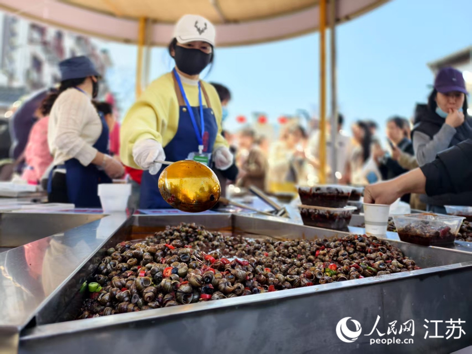 蔣壩市集現(xiàn)場售賣螺螄美食。人民網(wǎng)記者 馬曉波攝