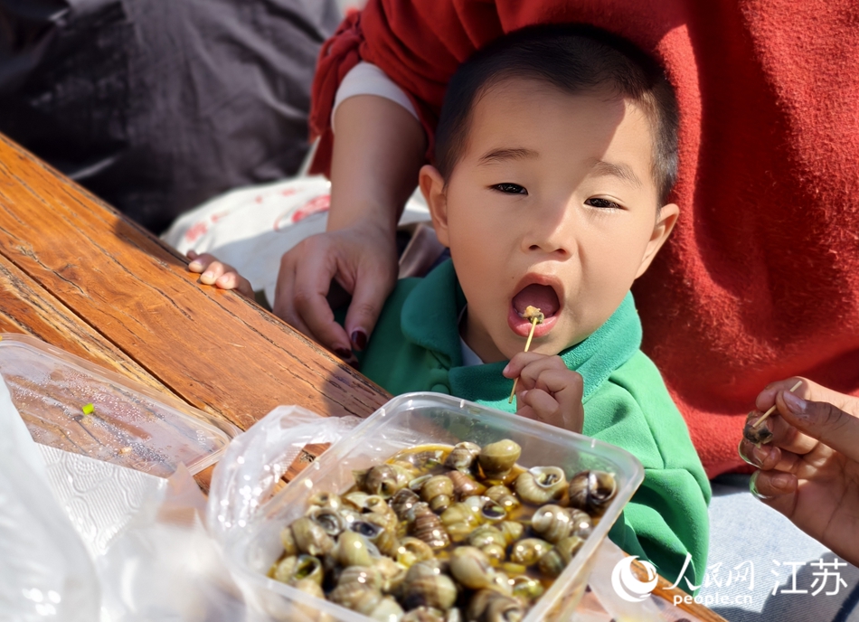 小朋友品嘗螺螄美食。人民網(wǎng)記者 馬曉波攝