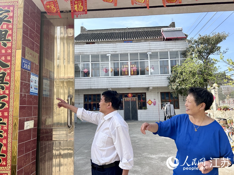 楊呈高老兩口展示自家“文明家庭”標(biāo)牌。人民網(wǎng) 王丹丹攝