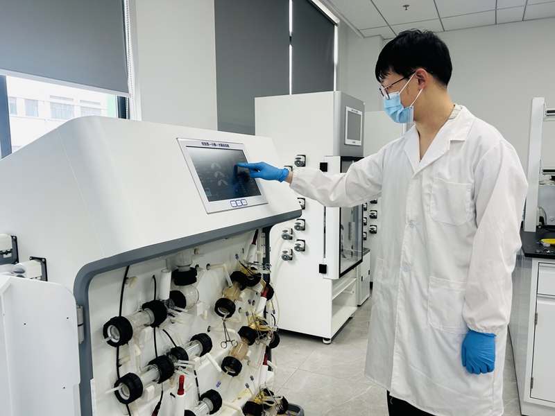 江蘇源橋生物科技有限公司工作人員在仿生消化反應(yīng)器前觀察進(jìn)樣結(jié)果。泰興融媒體中心供圖