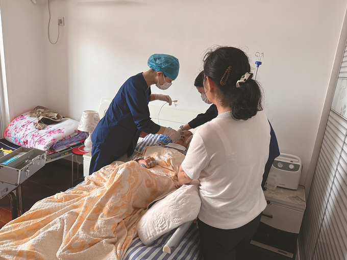 南京市浦口人民醫(yī)院的護(hù)士正在進(jìn)行上門護(hù)理。 趙晶 攝