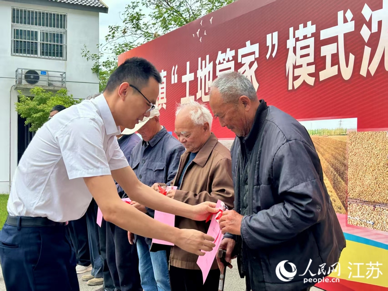 向村民發(fā)放土地保底收入和農(nóng)村基本醫(yī)療保險(xiǎn)費(fèi)用。人民網(wǎng) 王丹丹攝