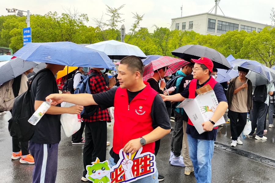 志愿者為排隊等候的人群發(fā)放礦泉水。王勇攝