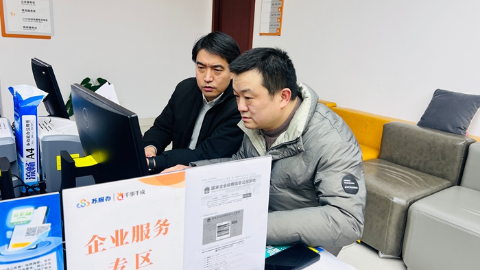 傅友雄（左一）到千燈鎮(zhèn)便民服務(wù)中心辦理業(yè)務(wù)。昆山市委組織部供圖
