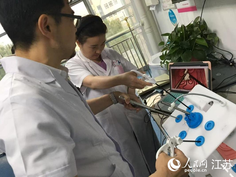 黃曉平指導(dǎo)徒弟阿娜爾模擬練習(xí)手術(shù)操作。人民網(wǎng) 俞楊攝