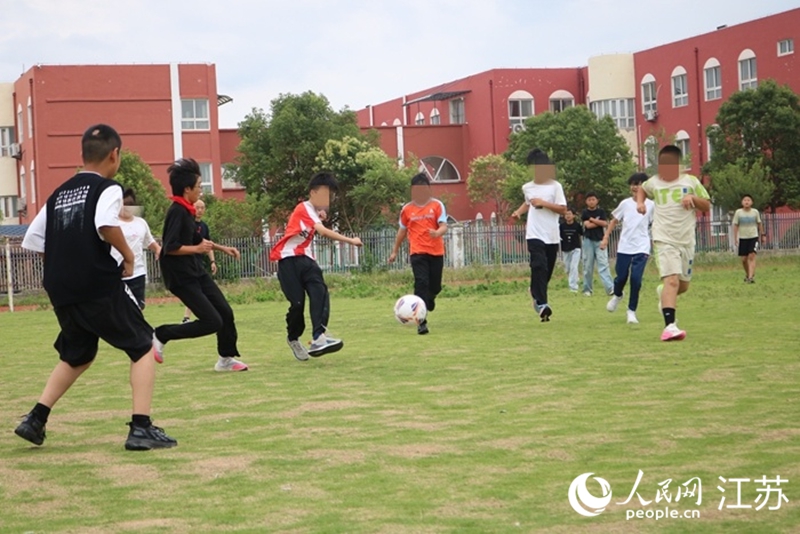 課后，東東（左五）與同學(xué)踢球。人民網(wǎng)記者 馬曉波攝