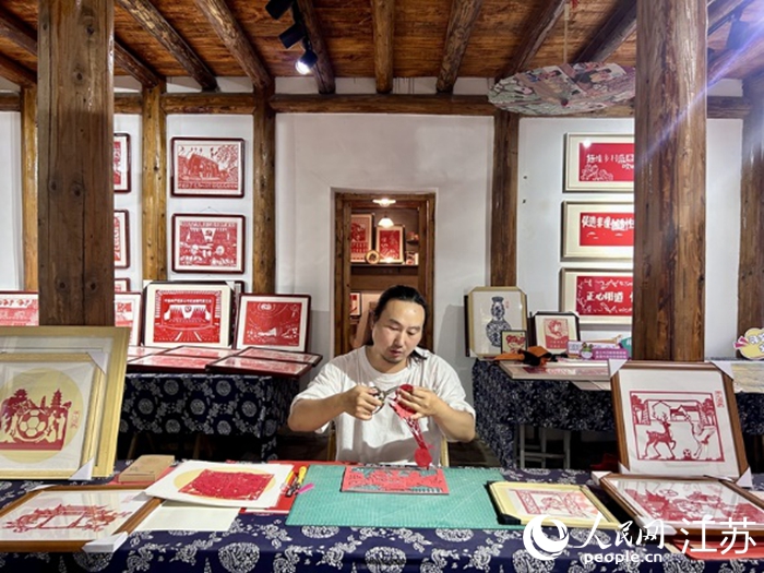 解善彪正在創(chuàng)作“蘇超”元素的非遺文創(chuàng)。人民網(wǎng) 王丹丹攝