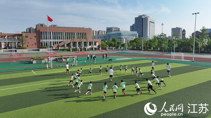南京游府西街小學浦口分校足球隊隊員們在操場訓練。人民網(wǎng) 余樂攝
