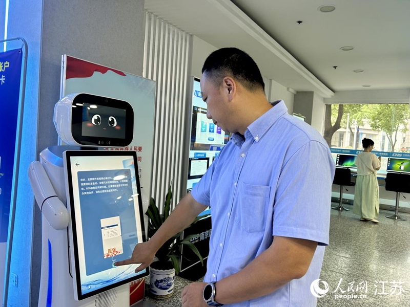 工作人員正在測試智慧醫(yī)保服務(wù)機器人。人民網(wǎng) 王丹丹攝