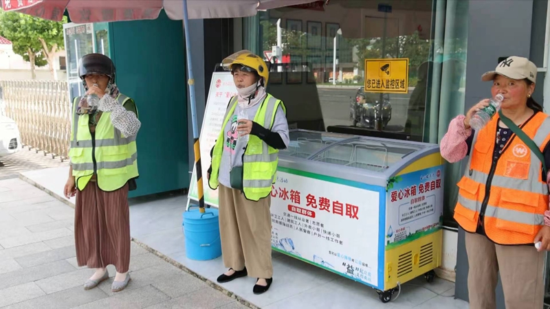 環(huán)衛(wèi)工人從“愛心冰箱”里取礦泉水解渴。成碩攝