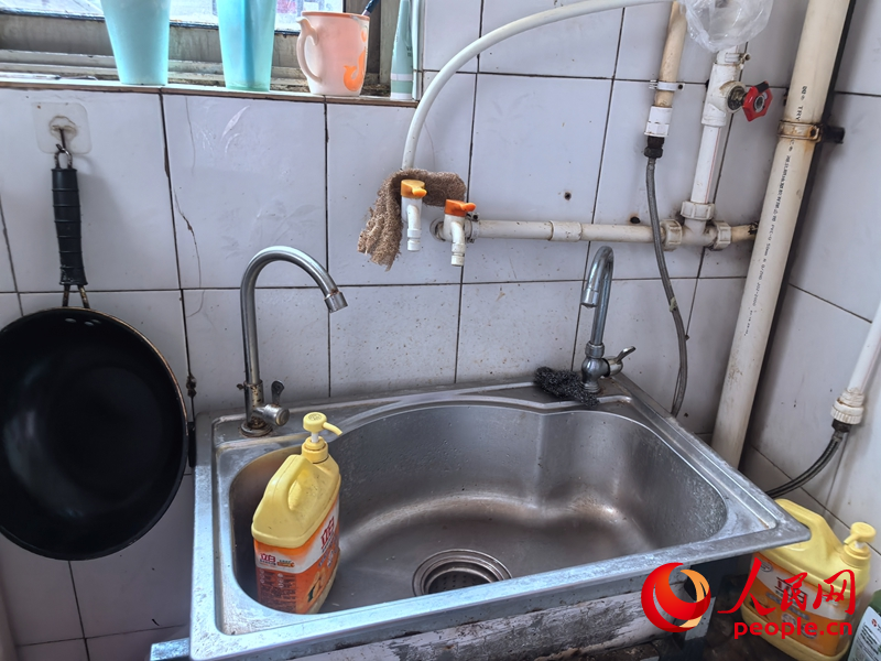 7月17日居民張桂芬家廚房，加裝3個水龍頭的洗碗池。 人民網(wǎng) 商帆攝