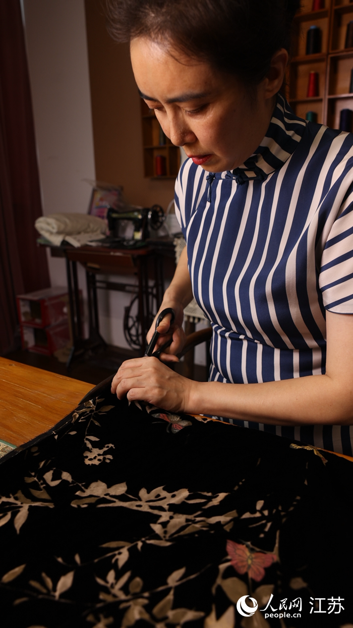 鄧麗元在裁剪布料。 人民網(wǎng) 范堯攝