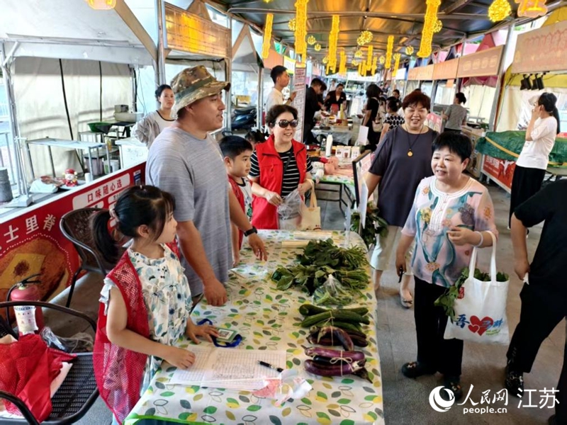 王維友帶著小鄰居在夜市擺起“一元蔬菜義賣”攤。人民網(wǎng)記者 馬曉波攝