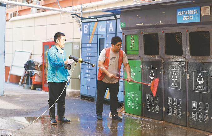 明瓦廊小區(qū)保潔員在清洗垃圾桶。 趙亞玲 攝