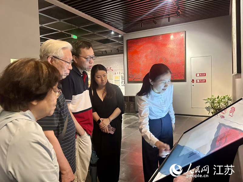 沙家浜革命歷史紀(jì)念館工作人員向游客介紹一體機(jī)上的行軍鞋。人民網(wǎng) 王丹丹攝
