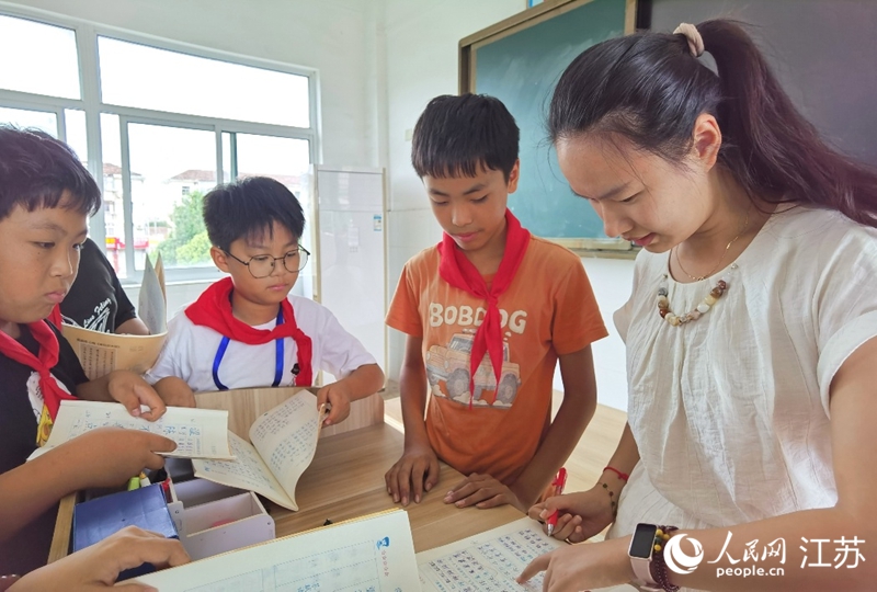 語文老師徐婕下課后給學生們輔導(dǎo)作業(yè)。人民網(wǎng)記者 王繼亮攝