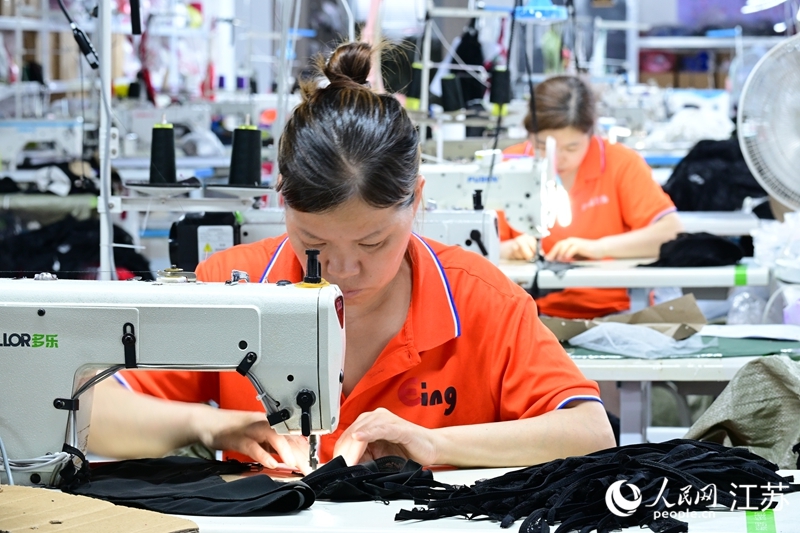 灌云伊影服飾有限公司車(chē)間內(nèi)，女工正在趕制服飾。人民網(wǎng)記者 張瀚天攝