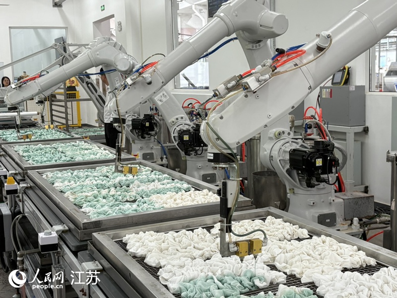 圖為扎染機(jī)器人正在注染。 人民網(wǎng) 劉益佳攝