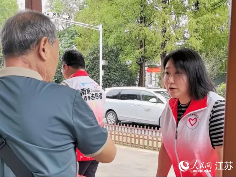 景區(qū)門口，志愿者在為游客講解乘車路線。人民網(wǎng) 崔小倩攝