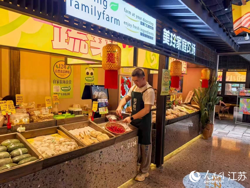 孫放在剪子股菜市里的攤位，經(jīng)營(yíng)自家農(nóng)場(chǎng)的蔬果。人民網(wǎng) 李欣陽(yáng)攝