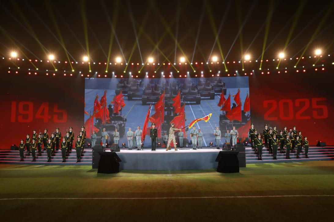 節(jié)目《戰(zhàn)旗美如畫》現(xiàn)場圖，九三閱兵陸軍方隊劉老莊籍參閱戰(zhàn)士嚴鵬飛現(xiàn)場講述，九三閱兵戰(zhàn)旗方隊"劉老莊連"戰(zhàn)旗擎旗手、劉老莊連現(xiàn)任副連長王宸一揮旗 。主辦方供圖