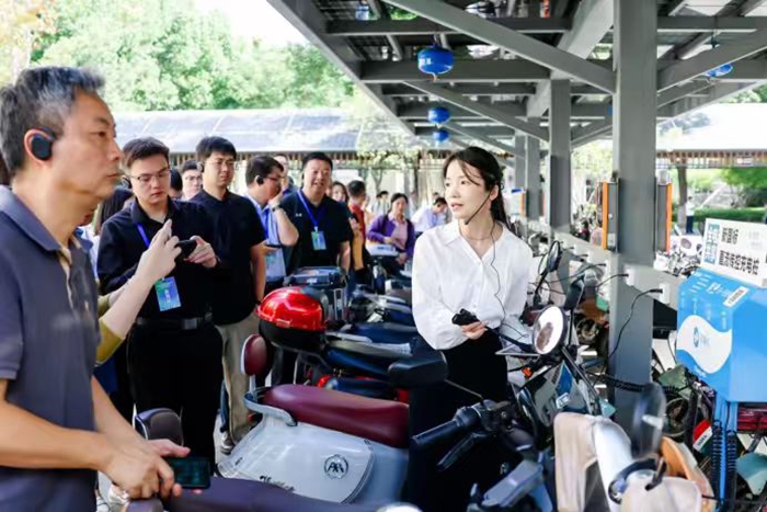 與會(huì)代表參觀蘇州“全電共享”便民充電車棚。朱清華攝