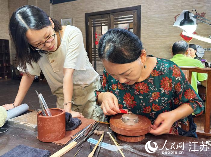 周菊英向年輕人傳授紫砂技藝。人民網(wǎng)記者 周夢(mèng)嬌攝