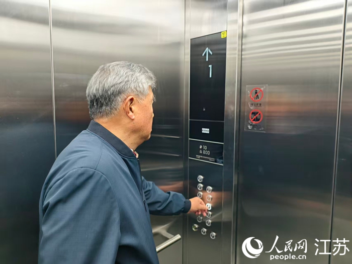 江南名府小區(qū)居民王樹立在使用電梯。人民網(wǎng)記者 馬曉波