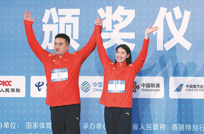 張雨霏領(lǐng)獎(jiǎng)前與教練一同慶祝比賽奪冠。 本報(bào)記者 萬程鵬 攝