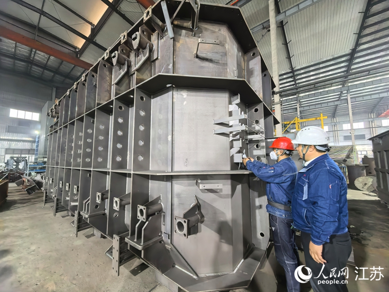 志和電氣工程師檢測大型變壓器配件。人民網(wǎng)記者 王繼亮攝