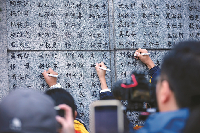 11月30日，南京大屠殺幸存者、南京大屠殺歷史記憶傳承人、南京大屠殺遇難同胞遺屬、青少年及志愿者代表等，聚集在南京大屠殺遇難者名單墻（又稱“哭墻”）前，一同祭奠在大屠殺中慘遭殺害的無辜同胞。 本報記者 萬程鵬 陳儼 攝