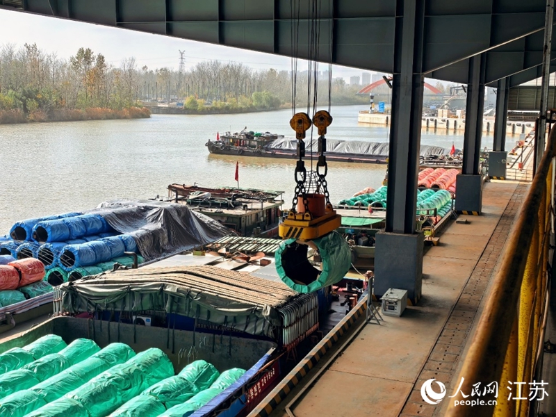 機械臂抓起鋼簾線盤條，通過專用傳輸帶直運到生產(chǎn)車間。人民網(wǎng) 崔小倩攝