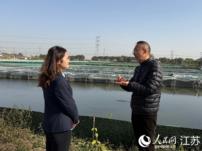 泰興郵儲客戶經(jīng)理（左）走訪螃蟹養(yǎng)殖戶。 人民網(wǎng) 任曉燃攝